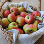 apples in basket with grey tea towel